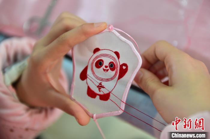 圖為一名小學(xué)生正在繡制2022年北京冬奧會(huì)吉祥物“冰墩墩”形象。　喻云亮 攝