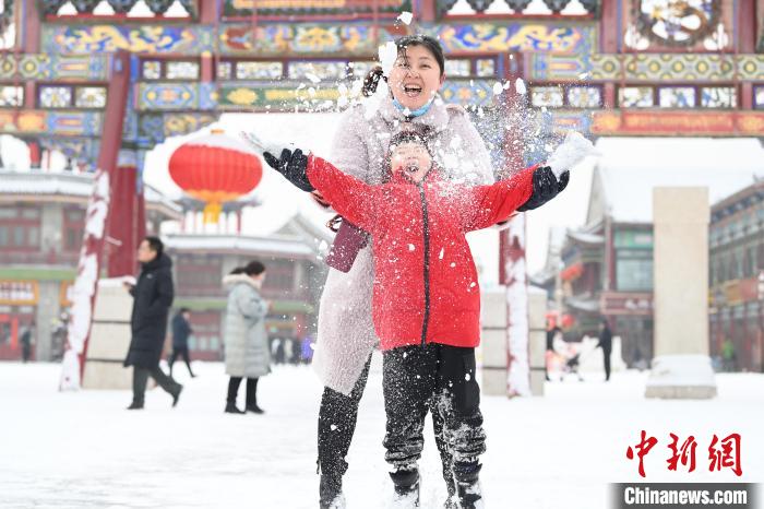 2月13日，家長與小朋友在呼和浩特市大召廣場享雪趣?！⑽娜A 攝