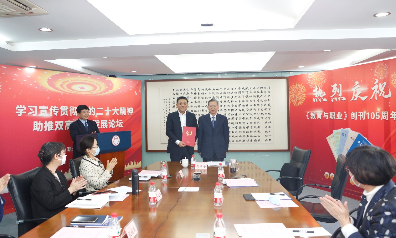 郝明金為《教育與職業(yè)》雜志編委代表陳曉明頒發(fā)聘書。中華職教社供圖