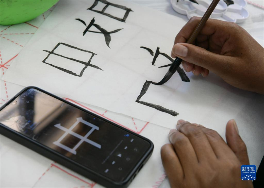 4月18日，肯尼亞學(xué)生在內(nèi)羅畢大學(xué)孔子學(xué)院舉辦的活動(dòng)上寫毛筆字?？夏醽唭?nèi)羅畢大學(xué)孔子學(xué)院18日舉辦“中文，增進(jìn)文明對(duì)話”主題活動(dòng)，慶祝即將到來的第14個(gè)聯(lián)合國(guó)中文日?？夏醽唽W(xué)生參與互動(dòng)，進(jìn)行書法、剪紙、唱中文歌等活動(dòng)。新華社記者 韓旭 攝