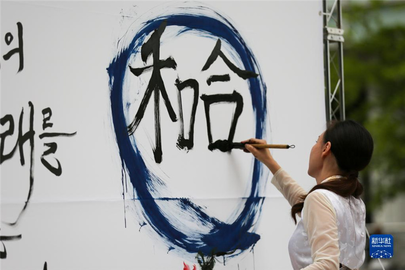5月30日，在韓國(guó)首爾舉辦的“中日韓合作之日”慶?；顒?dòng)中，表演者進(jìn)行中日韓精神——2023年度漢字“和合”書(shū)法表演。新華社記者 王益亮 攝