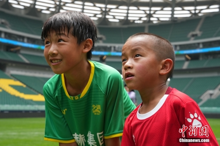 圖為北京國(guó)安小球員陳小北和7歲的俄金仁增在一起觀看場(chǎng)內(nèi)播放的紀(jì)錄片。<a target='_blank' href='/' _fcksavedurl='/'><p  align=