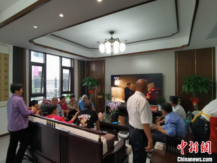 親友們集中在費(fèi)俊龍家中觀看返程的視頻。　鐘升 攝