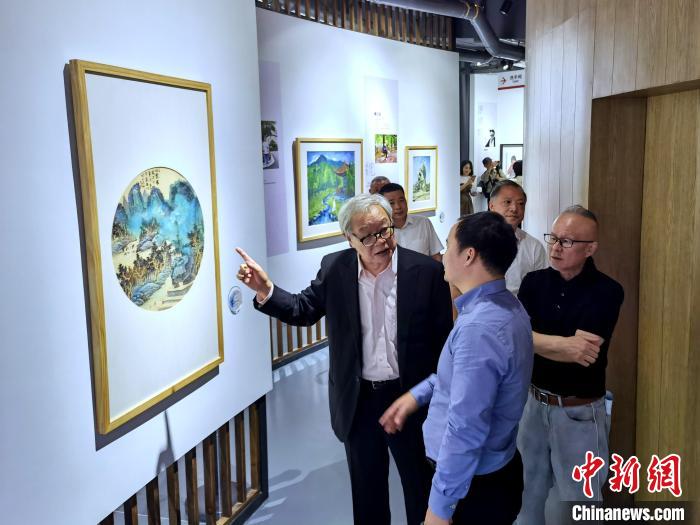 海峽兩岸藝術(shù)家畫展上，藝術(shù)家進(jìn)行藝術(shù)交流?！「毒窜?攝