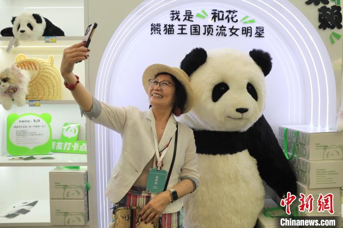 美國華視總裁楊蓮花與大熊貓文創(chuàng)產品合影?！⊥趵?攝