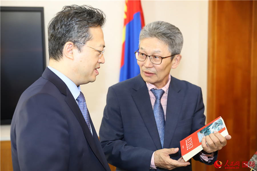 其米德策耶（右一）向李峙介紹翻譯成果。人民網記者 霍文攝