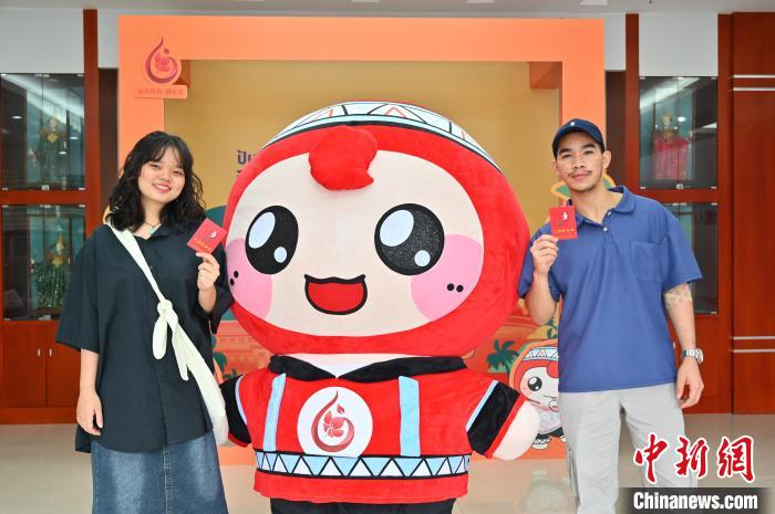 圖為泰國留學(xué)生手持獻血證與人偶合影。　俞靖 攝