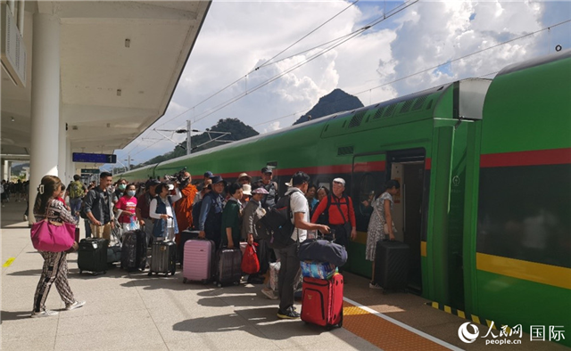 乘坐中老鐵路國際旅客列車的旅客在老撾瑯勃拉邦站排隊上車。人民網(wǎng)記者 杜明明攝