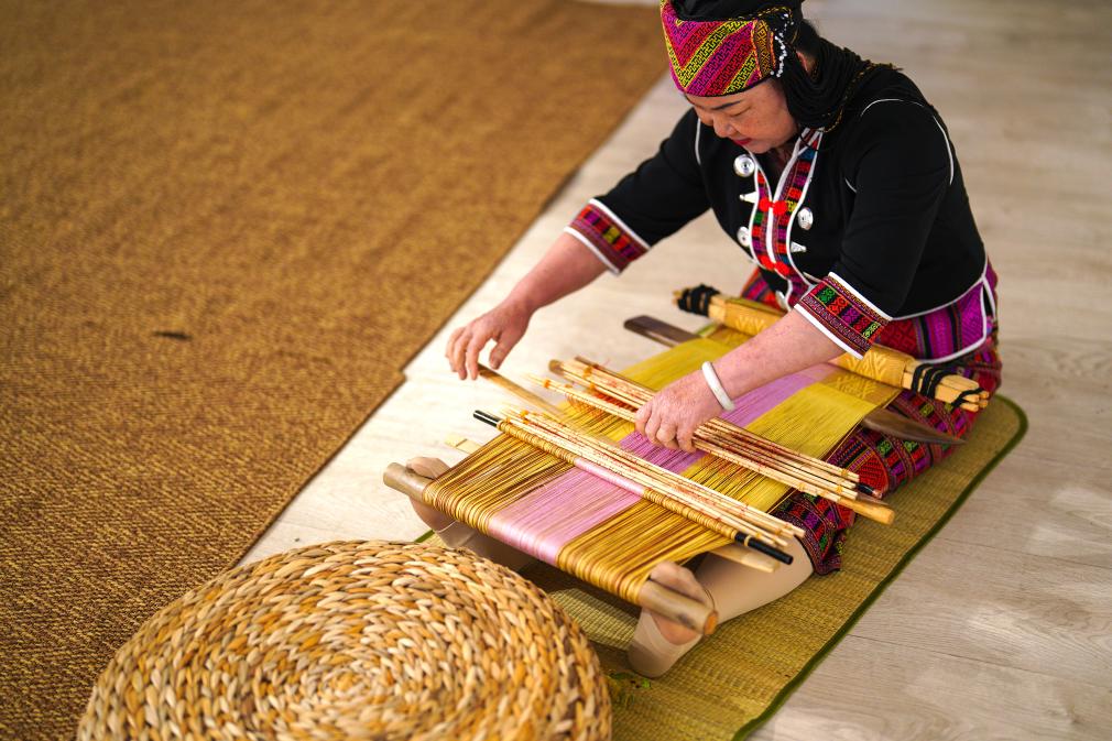 4月17日，黎族傳統(tǒng)紡染織繡技藝國家級(jí)代表性傳承人劉香蘭在2023年意大利米蘭設(shè)計(jì)周上展示黎錦織造技藝。新華社發(fā)
