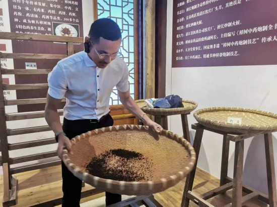 2023“一帶一路”媒體合作論壇聯(lián)合采訪團(tuán)團(tuán)員在非遺文化展示館體驗(yàn)中藥炮制技藝。（本報(bào)記者 黃超攝）