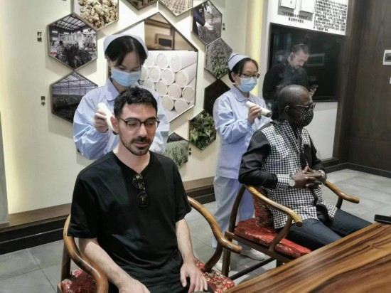 2023“一帶一路”媒體合作論壇聯(lián)合采訪團(tuán)團(tuán)員在九牛草展示館體驗(yàn)艾灸。（本報(bào)記者 黃超攝）