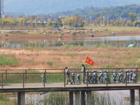 　　10月24日，秋游的幼兒園小朋友在老師帶領(lǐng)下走在清水塘公園里的木橋上。本報記者 常雯宜攝
