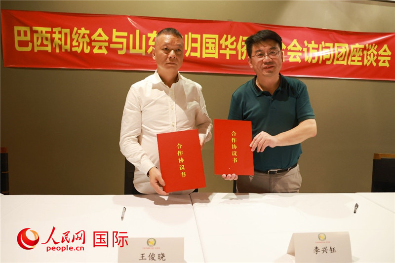 中國僑聯(lián)副主席、山東省僑聯(lián)主席李興鈺（右）與巴西和統(tǒng)會會長王俊曉簽署合作協(xié)議書。人民網(wǎng)記者 陳海琪攝
