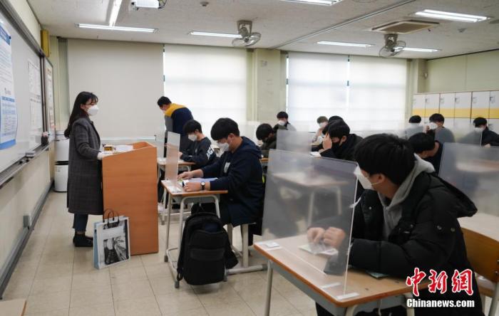 12月3日，延遲近一個(gè)月的韓國(guó)高考舉行。據(jù)韓國(guó)教育部消息，今年考生約49.34萬(wàn)人，創(chuàng)歷史最低紀(jì)錄。圖為在首爾某考點(diǎn)內(nèi)，考桌上設(shè)有隔板。