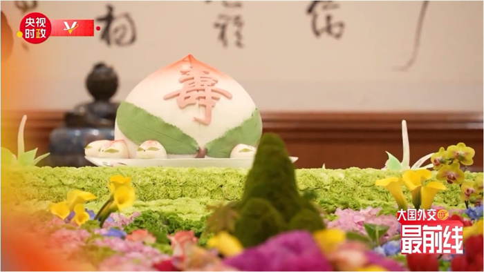 圖為今年7月基辛格訪華時(shí)午宴上的壽桃。來(lái)源：央視新聞截圖