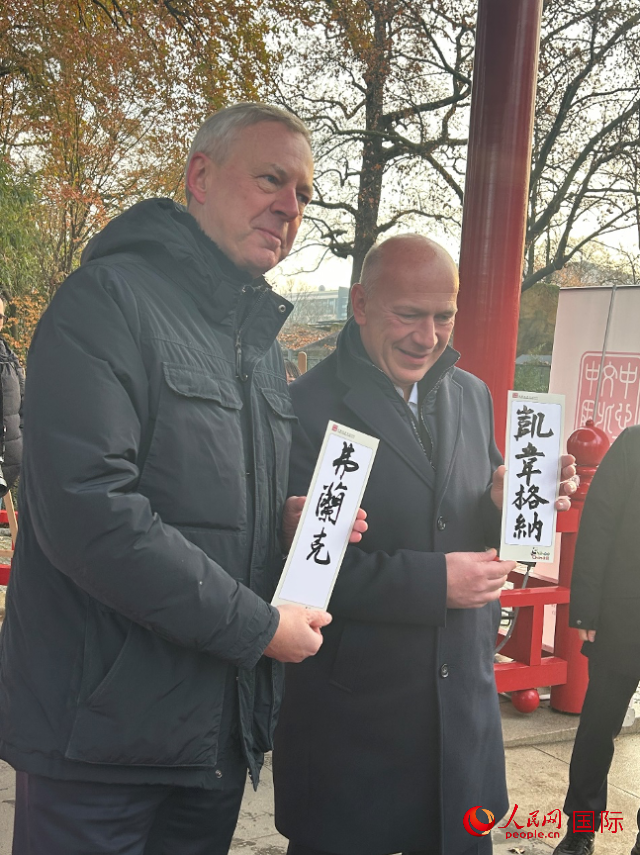 柏林市長韋格納（右）、動物園監(jiān)事會主席布魯克曼（左）手持中國文化中心工作人員現(xiàn)場手書的中文名字。人民網(wǎng)記者 徐馨攝