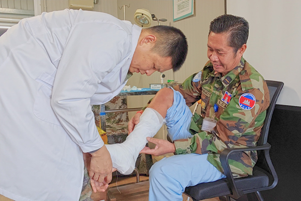 中國第22批赴黎維和醫(yī)療分隊軍醫(yī)為患者打石膏固定患肢。李清竹攝