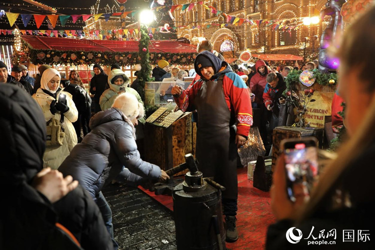 游客在新年集市上體驗(yàn)制作紀(jì)念幣。人民網(wǎng)記者 隋鑫攝