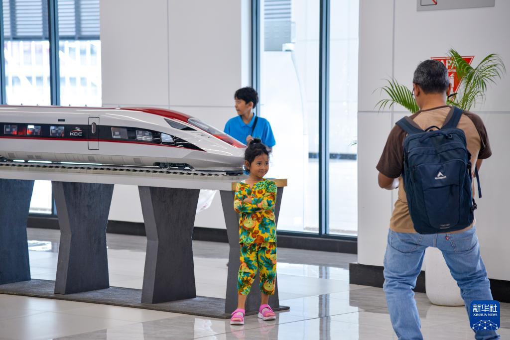 1月24日，在印度尼西亞雅加達(dá)哈利姆站候車大廳，一名小朋友和雅萬高鐵高速動車組模型合影。新華社記者 徐欽 攝