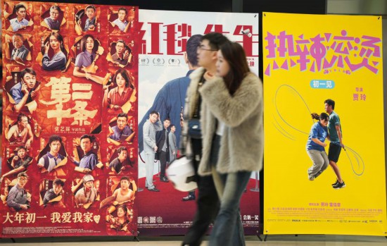 這是2月17日，在沈陽一家影院，觀眾從海報(bào)前經(jīng)過。新華社記者李鋼攝