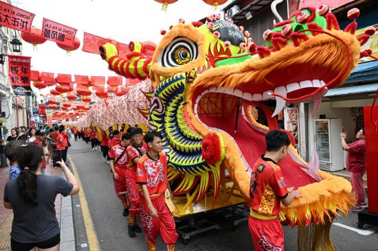2月1日，由馬來西亞和中國的100多名青少年組成的舞龍隊(duì)在馬來西亞馬六甲市雞場街上共舞一條近200米的“長龍”。這是活動(dòng)現(xiàn)場的“長龍”。新華社記者程一恒攝