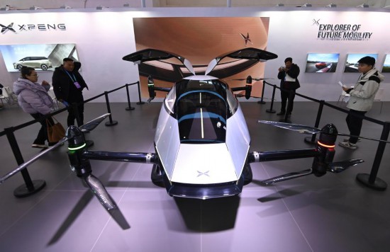 2023年12月1日，在鏈博會智能汽車鏈展區(qū)小鵬汽車展臺，參觀者觀看一臺智能飛行器。新華社記者蔡湘鑫攝