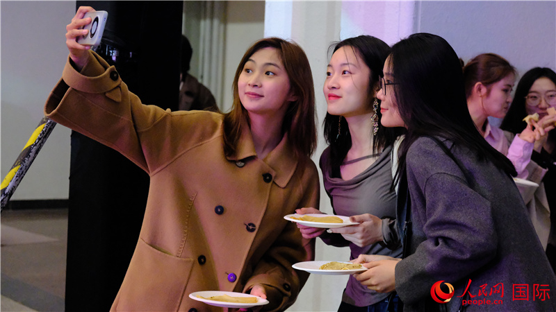 中國觀眾在現(xiàn)場品嘗“謝肉節(jié)”節(jié)日美食——煎薄餅。人民網(wǎng) 褚夢琦攝