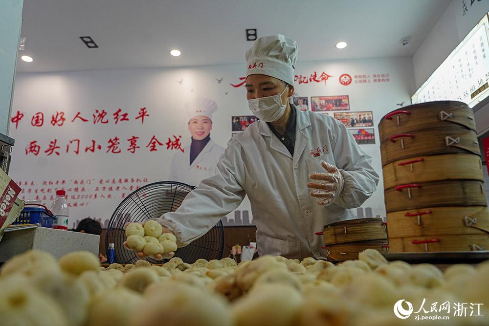 3月31日，在浙江省嵊州市甘霖鎮(zhèn)，嵊州小吃從業(yè)者沈紅平把蒸熟的小籠包晾涼，打包冷藏售賣。人民網(wǎng) 章勇濤攝