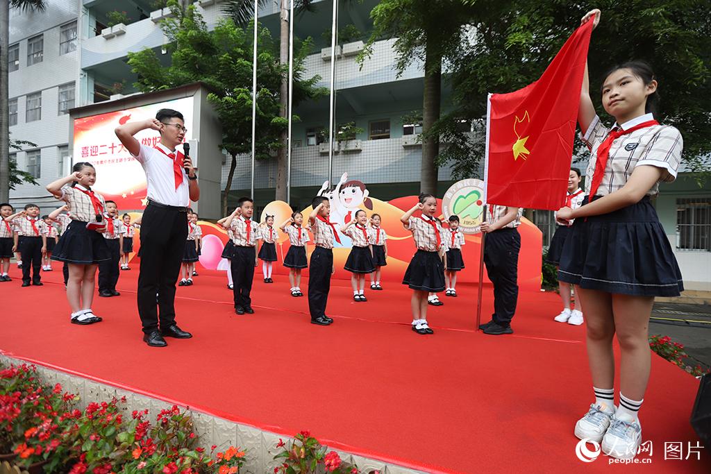 5月31日，在廣西壯族自治區(qū)南寧市民主路小學(xué)，學(xué)校大隊輔導(dǎo)員帶領(lǐng)少先隊員呼號。人民網(wǎng)記者 嚴(yán)立政攝