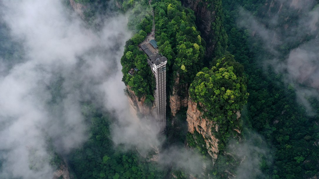 位于張家界武陵源景區(qū)的百龍?zhí)焯蓁偳对谠旗F繚繞的峰林間，雄偉壯觀。吳勇兵攝