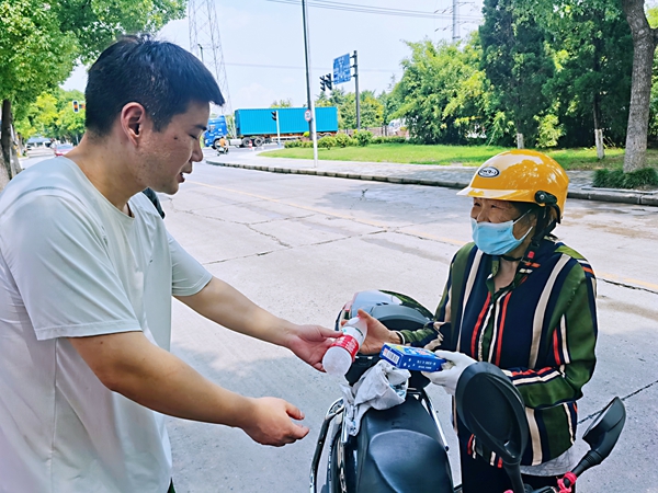 何超為過路的老人送上礦泉水和冷飲。人民網(wǎng)記者 王繼亮攝