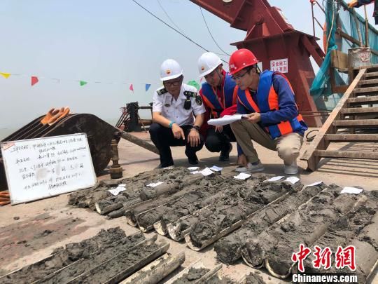 圖為勘察設計人員與海事局工作人員查看巖芯情況?！∥赫?攝