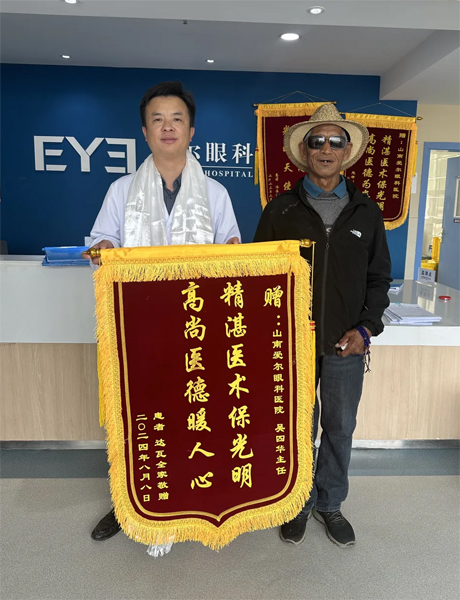 達瓦老人向吳四華（左）贈送錦旗。受訪者供圖