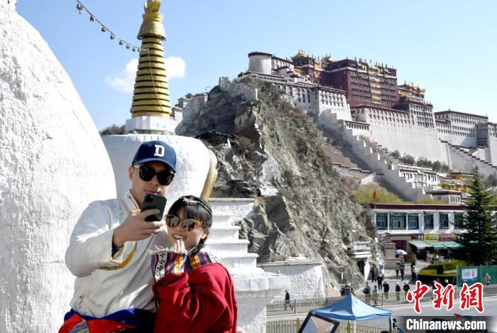 4月17日，游客身著藏式元素服裝在拉薩布達(dá)拉宮觀景臺(tái)拍照留念?！±盍?攝
