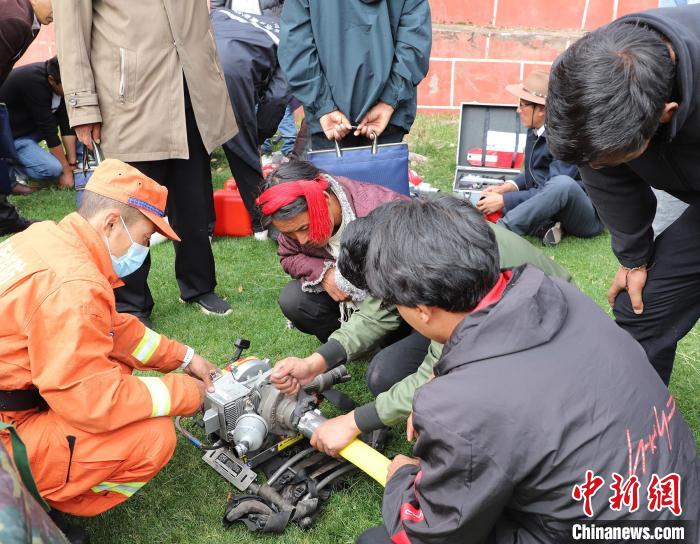 圖為森林消防員為護(hù)林員講解滅火裝備的使用方法。　昌都市森林消防支隊(duì) 供圖