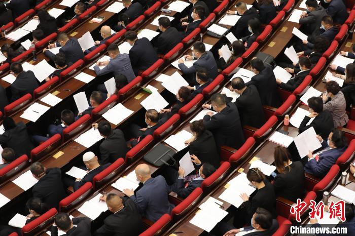 圖為會議現(xiàn)場，參會代表正在聽取政府工作報告?！∑钤鲚?攝