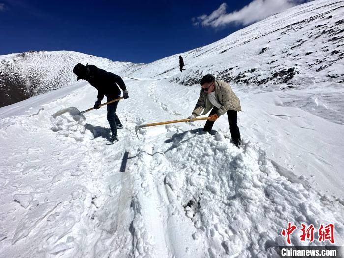 圖為生態(tài)管護人員在巡護道路上清雪。　丁巴達杰 攝