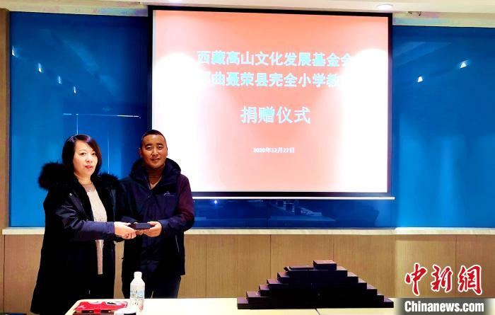 圖為西藏高山文化發(fā)展基金會理事長溫麗向聶榮縣完全小學(xué)負責人捐助儀器。　于賓 攝