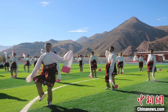 圖為青海師范大學(xué)附屬玉樹實驗學(xué)校學(xué)生在綠茵場跳起囊謙古舞—卓根瑪?！〕逃?攝