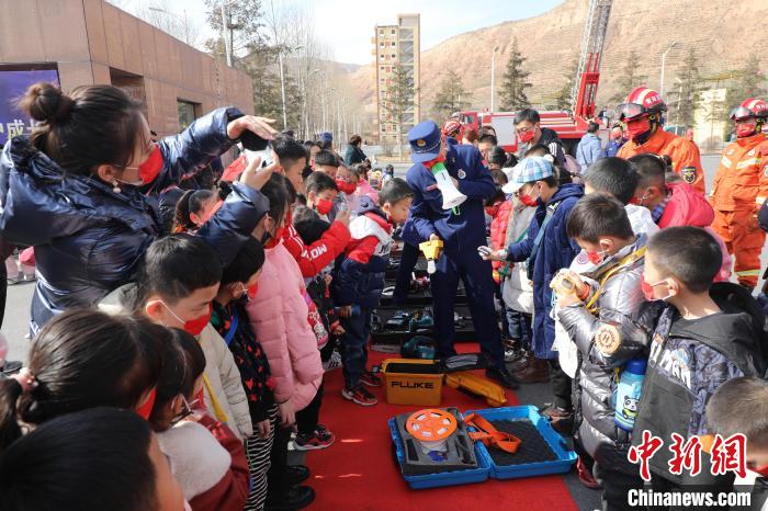 圖為小朋友們聽消防員講解消防器材?！铨埥?攝