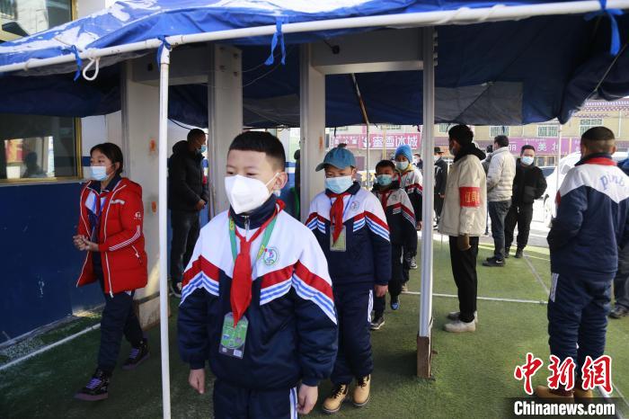 圖為學(xué)生測量體溫后進入校園?！●R銘言 攝
