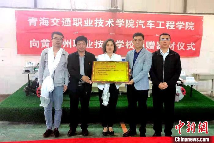 圖為李富香(中)代表學(xué)校為州縣技校捐贈器材。(資料圖) 青海省教育廳供圖