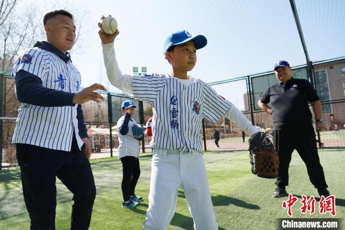 圖為教練指導(dǎo)小棒球手?jǐn)S球技術(shù)?！●R銘言 攝