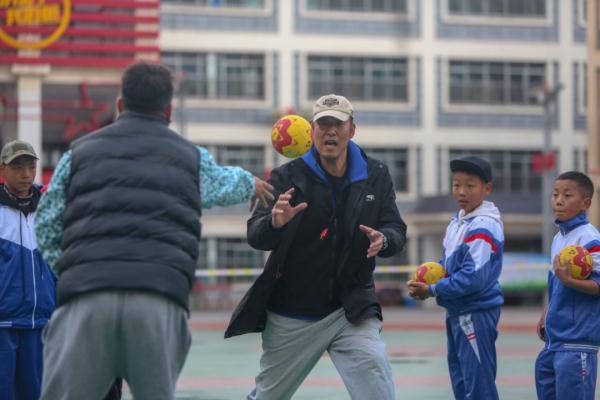 在高原上教孩子們打手球，“慢慢兒來，甭著急！”