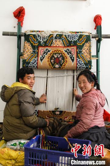 圖為1月15日，在日喀則市謝瑪氆氌農(nóng)村合作社，拉孜村一對(duì)夫婦在編織卡墊(資料圖)。　趙朗 攝