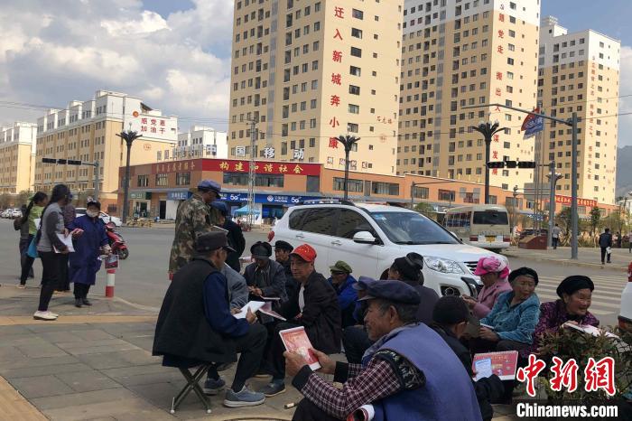 圖為會澤縣城易地扶貧搬遷安置點內(nèi)，老人們聚在廣場上聊天，身后是他們的新家?！】姵?攝