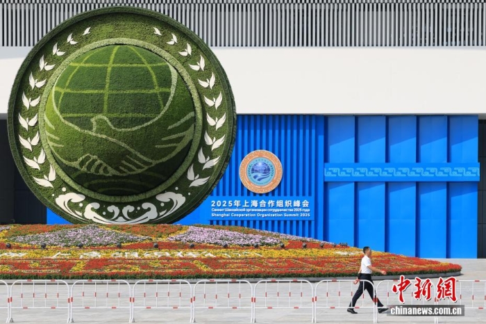 8月31日，天津，一名工作人員從2025年上海合作組織峰會主會場外的景觀花壇旁經(jīng)過。當日，2025年上海合作組織峰會在天津舉行。<a target='_blank' href='/'><p  align=