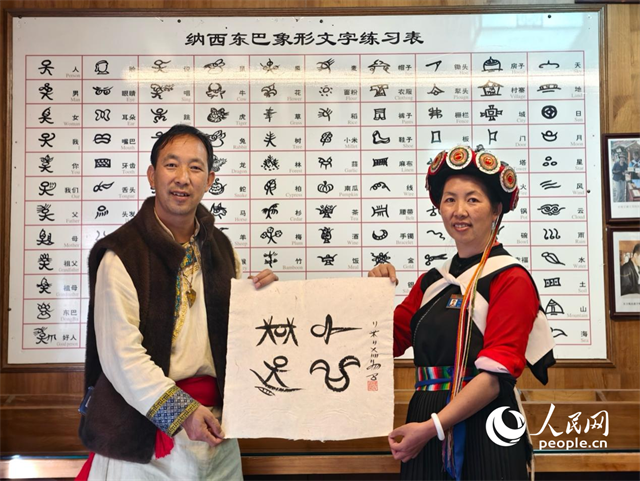 人民網(wǎng)“行進中國”云南調(diào)研采訪團走進麗江，和閏元現(xiàn)場用東巴文寫下“行進中國”。人民網(wǎng)記者 符皓攝