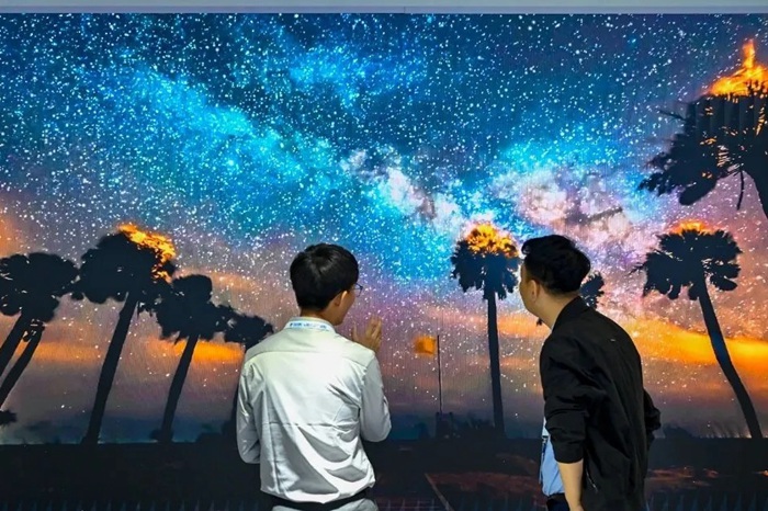 長春光博會(huì)希達(dá)電子展區(qū)，一位工作人員正在給一位觀眾講解。（長春新區(qū)供圖）
