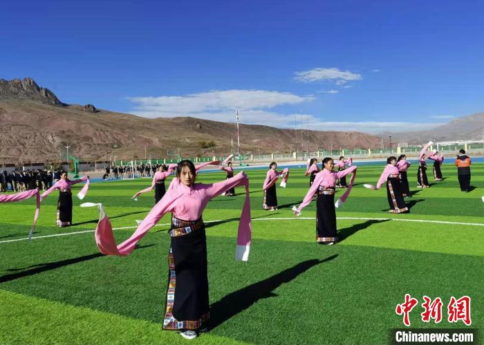 圖為青海師范大學(xué)附屬玉樹實驗學(xué)校學(xué)生在綠茵場跳起囊謙古舞—卓根瑪?！“讋?攝